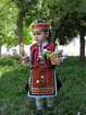 Traditional costume for a child from Nikopol, Bulgaria. Pishtimal, apron, vest, head ornaments, belt